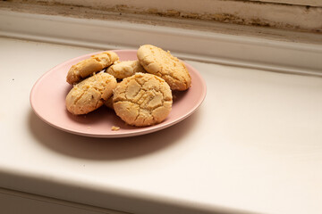 pink plate with homemade cookies on white antique stove top