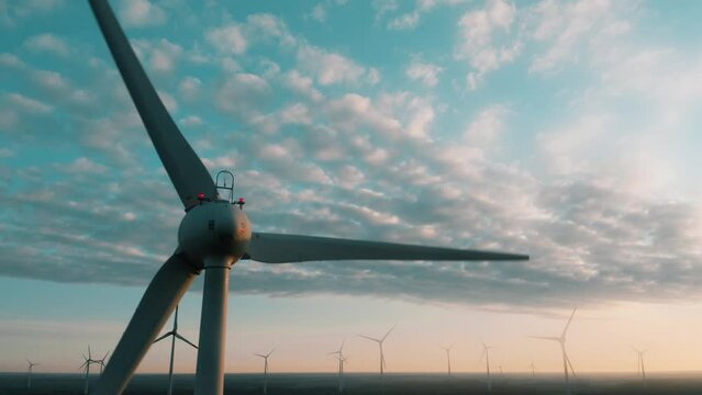 Wind turbines at sunrise aerial view. Wind farm generating green energy, producing electricity. Concept of renewable sustainable energy