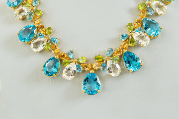 Gold necklace with multicolored gemstones, elegant jewelry design.