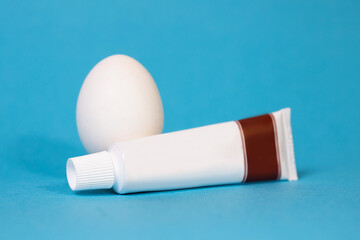egg and a tube of toothpaste on a blue background