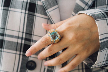 Woman wearing blue topaz ring, looks luxurious and elegant.