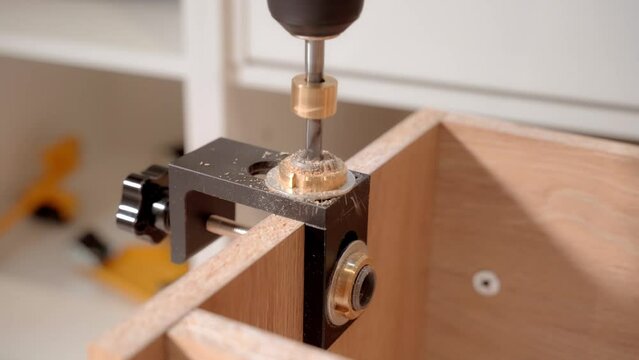 The master uses a jig template and an electric screwdriver to drill holes when assembling the cabinet. 4k
