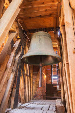 a big old bell hanging in a wooden church's old tower