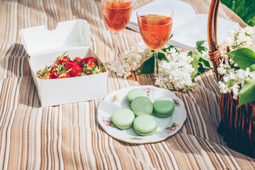 Box with fresh strawberry, pink lemonade, dessert macaroons, berry lemonade, basket with lilac