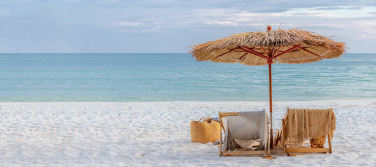 beautiful tranquil white sand beach with two beach chair and thatched umbrella with copy space....