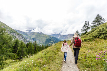 Fototapeta na wymiar Mother and to children going for a walk in mountain surroundings