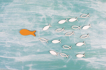 Orange fish is the leader of the group, leadership and teamwork concept, be a winner, success and start up in business, follow a new idea  - obrazy, fototapety, plakaty