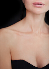 Fototapeta na wymiar Beauty women lips nude makeup, beautiful neck and neckline, clean skin on black background