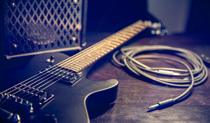Naklejka premium Close-up, black electric guitar on a dark background.
