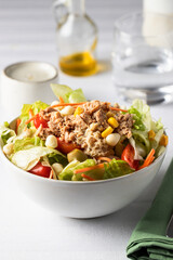 Close up of Restaurant table with  tuna salad bowl with different lettuce and vegetables .