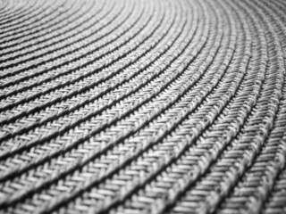 Close-up of gray wicker fabric with trails twisted in a circle.