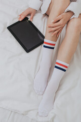 Obraz premium young woman wearing white shirt is reading book in bed enjoying literature in nice bedroom. Leisure activities and intelligent people concept.