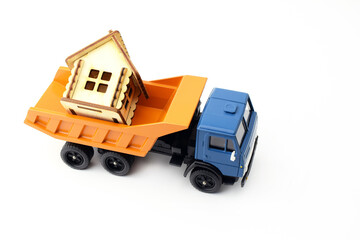 Cargo miniature car carries toy house, isolate on white. The concept of a moving or delivery service.