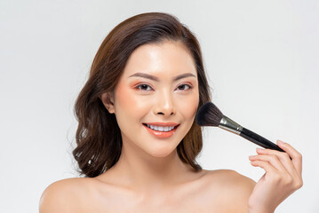 Obraz na płótnie Canvas Glad Thai female applying face powder with brush