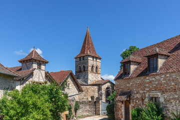 Fototapeta na wymiar Masonry tiled roof houses in center of ancient Carennac village and 11 century Church Eglise Saint-Pierre
