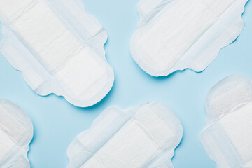 Women hygiene products or sanitary pad on colored background. Pastel color. Closeup. Empty place for text. Female daily hygiene - obrazy, fototapety, plakaty