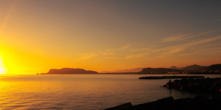 Sunrise at Foro Italico Coast of Palermo on Sicily in Europa, Italy in late spring April on a warm sunny orange day