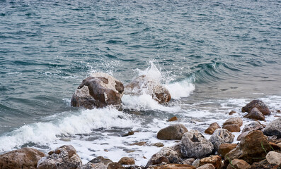 Dead Sea. Jordan. Close-up. Salt crystals on huge boulders along the coast. Close-up. Stone beaches along coast of Dead Sea are washed by foamy emerald waters.