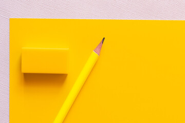 top view of pencil near eraser on yellow and white.