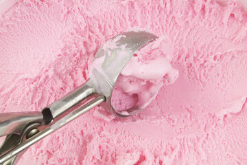 Strawberry ice cream and ice-cream scoop close up