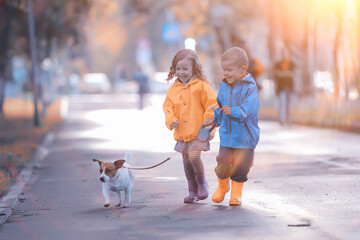 children dog autumn / two children, a boy and a girl walking with a small dog in the autumn park