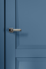 Stainless stylish door knob on blue wooden door