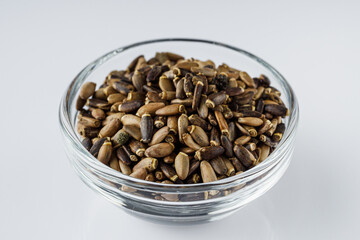milk thistle seeds on a white acrylic background
