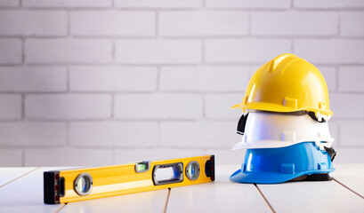 Contractor theme. Equipment of the contractor: yellow, white and blue hardhats, libella, hand saw....