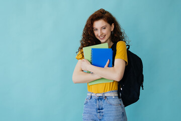 Teenager student girl isolated on blue background posing with arms at hip and smiling