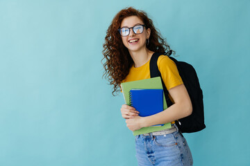 Teenager student girl isolated on blue background posing with arms at hip and smiling