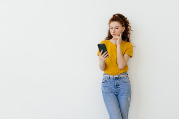 Young woman reading message on smartphone and smiling, social networking while standing over white background