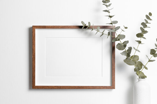 Wooden frame mockup on white wall with copy space for artwork, photo or print presentation.