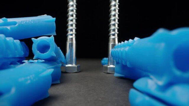 Blue plastic wall plugs on black table. Dolly slider extreme close-up. Laowa Probe
