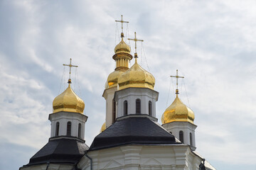 Fototapeta na wymiar Gilded domes of an ancient Orthodox church against the sky. Catherine's Church is a functioning church in Chernihiv, Ukraine. St. Catherine's Church was built in the Ukrainian Baroque style.
