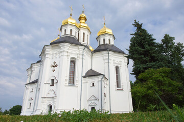 Fototapeta na wymiar Beautiful cloudy sky over the ancient Orthodox Church of St. Catherine in the Ukrainian city of Chernihiv. An example of Ukrainian baroque architecture. Church is distinguished by its five gold domes.