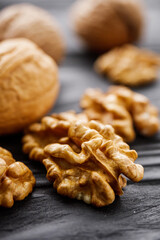 dried walnuts on a black rustic wooden background