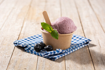 Blueberry ice cream scoop on wooden table	