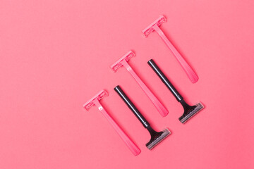 Skin Care Ideas. Flatlay Upper View Image of Five Colorful Pink and Black Disposable Razors Shavers Placed Reversed Over Trendy Pink Coral Background.