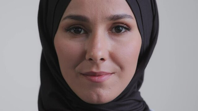 Close-up arabian human female face islam woman with natural makeup clear skin attractive pretty muslim girl wearing traditional hijab scarf standing indoors front looking at camera confident eyesight