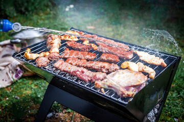 Making barbeque in nature. Barbecue with meat and fire for holidays. Tasty BBQ on picnic day.