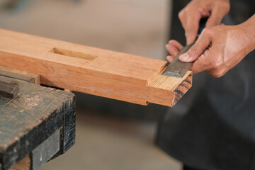 Carpenter working on wood craft at workshop to produce construction material or wooden furniture