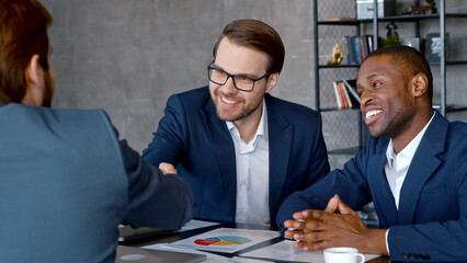Meeting in the loft: Handshake of a young business people