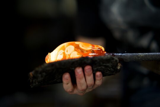 Souffleur de verre - modelage verre chaud mouillette couleur orange - artisan travailleur en action