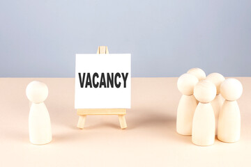 VACANCY text on easel with wooden figure, meeting concept