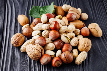 set of different nuts on a black rustic wooden background