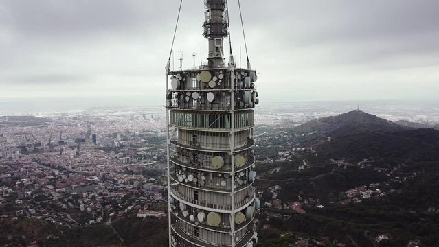 Collserola television tower with aircraft warning lights blinking in the overcast dawn sky. Orbit aerial shot.