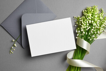 Invitation or greeting card mockup with envelope and lily of the valley flowers © nikavera