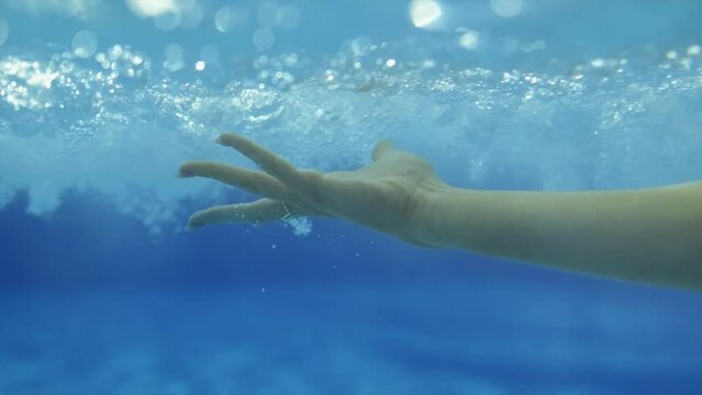 female hand making gestures underwater. slow motion,close up.4K
female hand underwater.