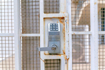 Digital key access lock on a beige metal gate at Silicon Valley, San Jose, California