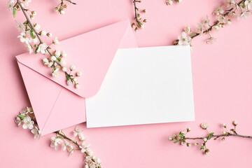 Greeting card mockup with envelope and white flowers on pink background